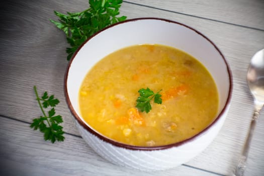 dried pea soup in a plate with herbs, on a wooden table.