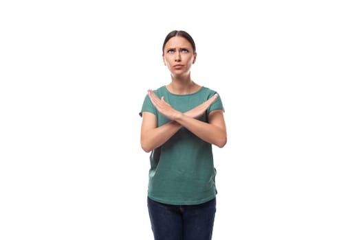 young confident slender woman dressed in a green basic t-shirt with print mockup crossed her arms in front of her.