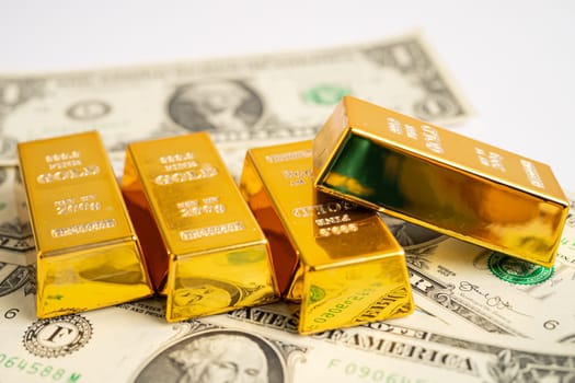Gold bar on US dollar banknotes money and graph, economy finance exchange trade investment concept.