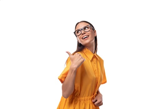 young well-groomed woman with black straight hair dressed in a yellow dress attracts attention.