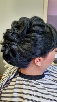 Wedding and holiday hairstyle. Braiding and hair styling in a beauty salon. Copy space