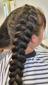 Wedding and holiday hairstyle. Braiding and hair styling in a beauty salon. Copy space