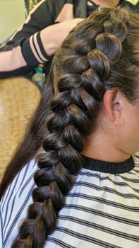 Wedding and holiday hairstyle. Braiding and hair styling in a beauty salon. Copy space