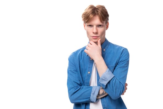 portrait of a pensive caucasian red-haired guy in a denim blue shirt.
