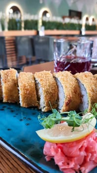 Sushi sets, rolls with caviar, shrimp, tuna, avocado and Philadelphia cheese on a colored plate in a fast food restaurant. Copy space