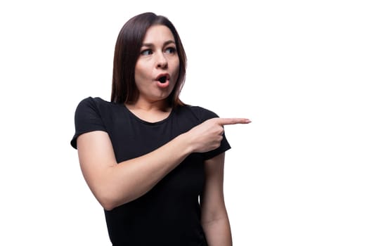 Caucasian young brunette woman with black hair points her finger in surprise.