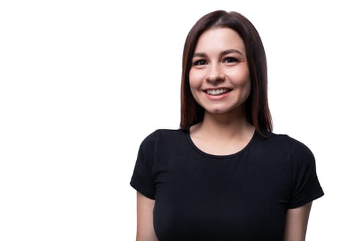 Positive pretty young brunette woman wearing a black t-shirt on a white background with copy space.