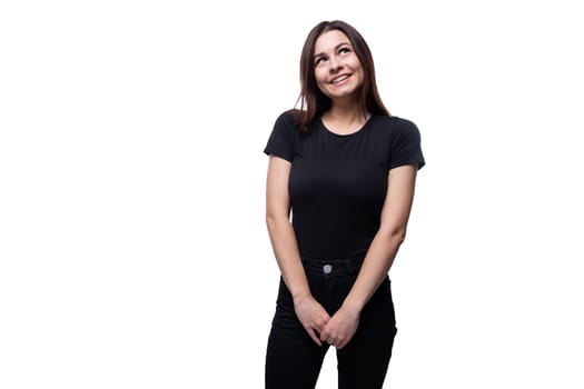 Young European woman dressed in a black T-shirt smiling on a white background with copy space.