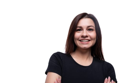 Young friendly woman with black hair wearing a black T-shirt on a white background with copy space.