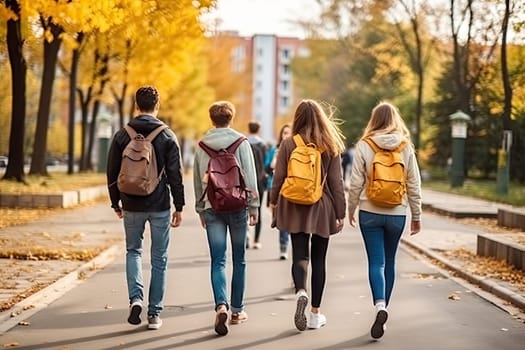 Rear view of two happy cute children, age 15, walking side by side on the street in the school area.by Generative AI.