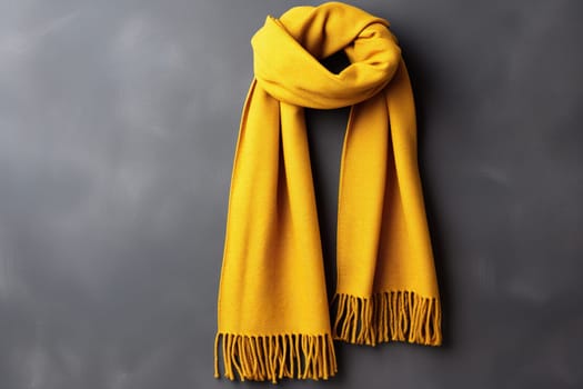 Yellow warm scarf on a background of a gray concrete wall. Option to wear a scarf.