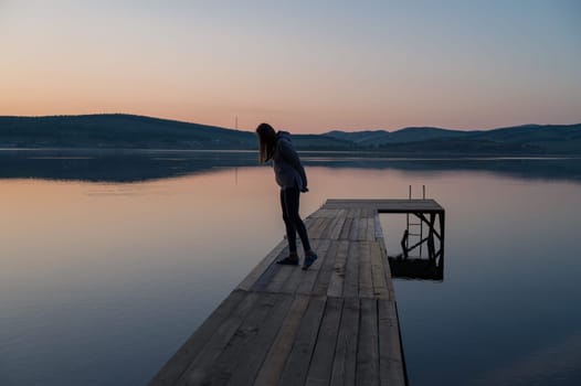 Woman on the pier at lake, closeup portrait, summer sunset