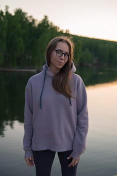 Woman on the pier at lake, closeup portrait, summer sunset