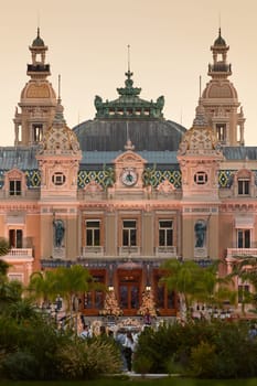 Monaco, Monte-Carlo, 12 November 2022: The famous square of Casino Monte-Carlo is at dusk, attraction night illumination, luxury cars, players, tourists, splashes of fountain. High quality photo