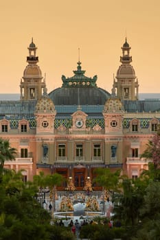 Monaco, Monte-Carlo, 12 November 2022: The famous square of Casino Monte-Carlo is at dusk, attraction night illumination, luxury cars, players, tourists, splashes of fountain. High quality photo