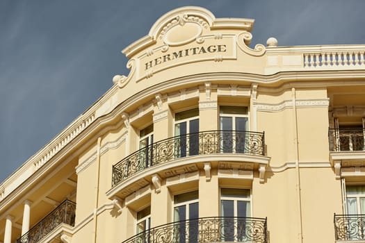 Monaco, Monte Carlo, 27 September 2022: The facade of famous Hotel Hermitage at sunny day, building of yellow color, balcony, bas-relief. High quality photo