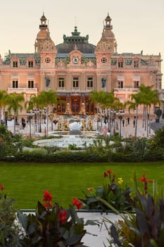 Monaco, Monte-Carlo, 12 November 2022: The famous square of Casino Monte-Carlo is at dusk, attraction night illumination, luxury cars, players, tourists, splashes of fountain. High quality photo