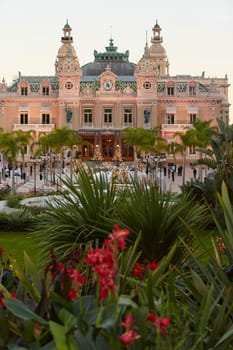 Monaco, Monte-Carlo, 12 November 2022: The famous square of Casino Monte-Carlo is at dusk, attraction night illumination, luxury cars, players, tourists, splashes of fountain. High quality photo