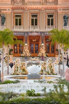 Monaco, Monte-Carlo, 12 November 2022: The famous square of Casino Monte-Carlo is at dusk, attraction night illumination, luxury cars, players, tourists, splashes of fountain. High quality photo