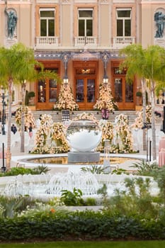 Monaco, Monte-Carlo, 12 November 2022: The famous square of Casino Monte-Carlo is at dusk, attraction night illumination, luxury cars, players, tourists, splashes of fountain. High quality photo