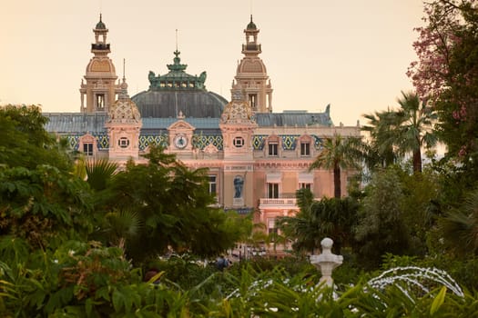 Monaco, Monte-Carlo, 12 November 2022: The famous square of Casino Monte-Carlo is at dusk, attraction night illumination, luxury cars, players, tourists, splashes of fountain. High quality photo