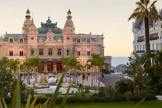 Monaco, Monte-Carlo, 12 November 2022: The famous square of Casino Monte-Carlo is at dusk, attraction night illumination, luxury cars, players, tourists, splashes of fountain. High quality photo