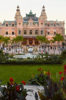 Monaco, Monte-Carlo, 12 November 2022: The famous square of Casino Monte-Carlo is at dusk, attraction night illumination, luxury cars, players, tourists, splashes of fountain. High quality photo