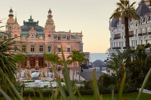 Monaco, Monte-Carlo, 12 November 2022: The famous square of Casino Monte-Carlo is at dusk, attraction night illumination, luxury cars, players, tourists, splashes of fountain. High quality photo