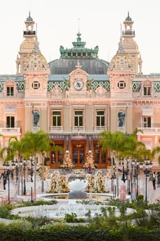 Monaco, Monte-Carlo, 12 November 2022: The famous square of Casino Monte-Carlo is at dusk, attraction night illumination, luxury cars, players, tourists, splashes of fountain. High quality photo