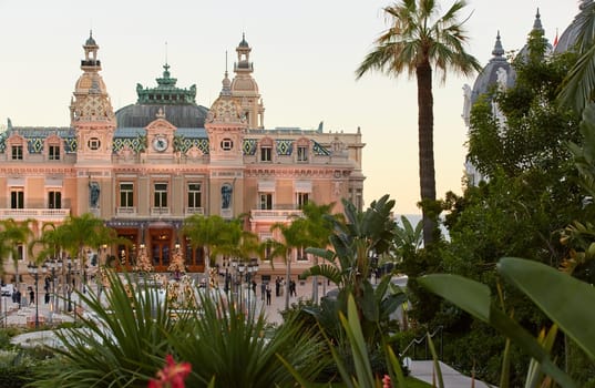 Monaco, Monte-Carlo, 12 November 2022: The famous square of Casino Monte-Carlo is at dusk, attraction night illumination, luxury cars, players, tourists, splashes of fountain. High quality photo