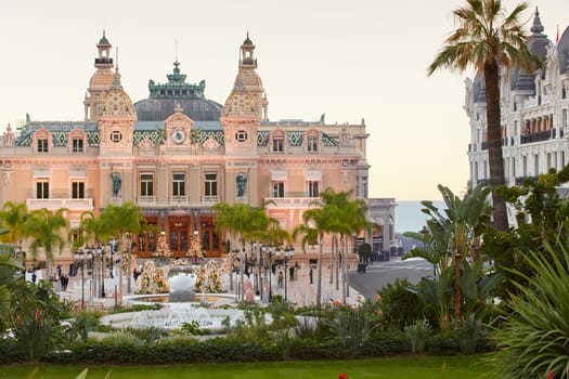 Monaco, Monte-Carlo, 12 November 2022: The famous square of Casino Monte-Carlo is at dusk, attraction night illumination, luxury cars, players, tourists, splashes of fountain. High quality photo