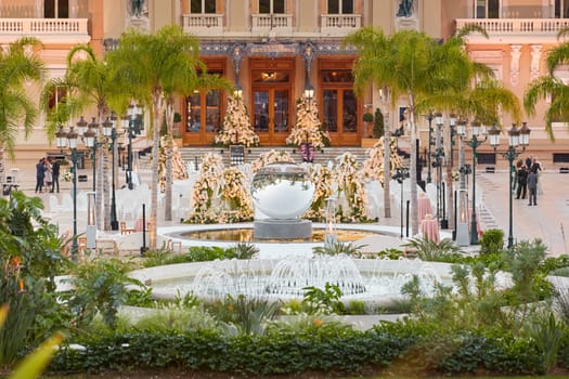 Monaco, Monte-Carlo, 12 November 2022: The famous square of Casino Monte-Carlo is at dusk, attraction night illumination, luxury cars, players, tourists, splashes of fountain. High quality photo