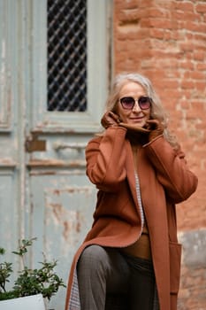 Woman in terracotta coat and leather gloves