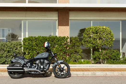 Monaco, Monte Carlo, 20 October 2022: Britain's Triumph motorcycle model 1901 of grey color standing on the street at sunny day, motorcycle helmet hanging on the handlebars of a motorcycle. High quality photo