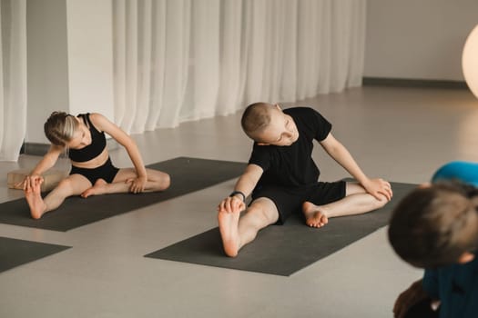 Children do yoga in the gym under the guidance of an instructor. Children's gymnastics.