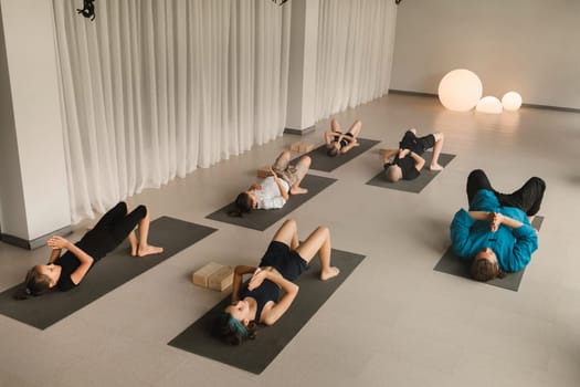 Children do yoga in the gym under the guidance of an instructor. Children's gymnastics.