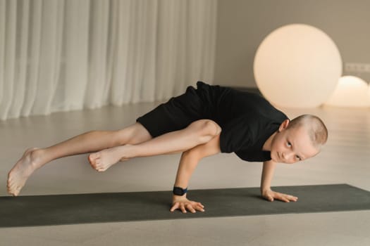 A child practices yoga poses indoors. Children's yoga.