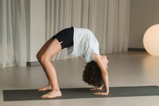 A child practices yoga poses indoors. Children's yoga.