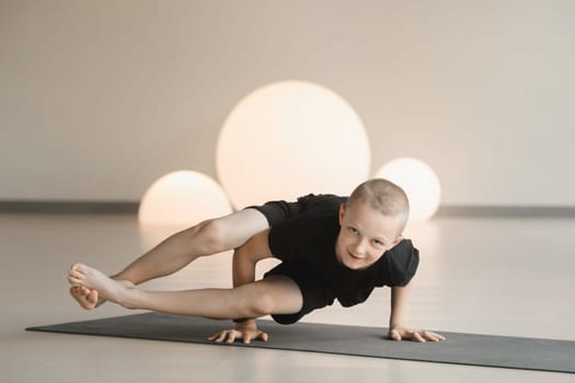 A child practices yoga poses indoors. Children's yoga.