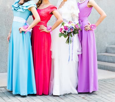 Bride with bridesmaids on the park on the wedding day