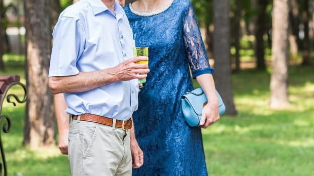 senior couple with glass of champagne outdoors.