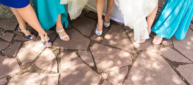 Bride and bridesmaids show off their shoes at wedding