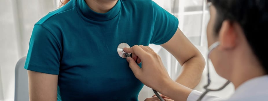 Patient attend doctor's appointment at clinic or hospital office. Doctor examining and diagnosis symptoms while checking the patient's pulse with stethoscope. Panorama Rigid