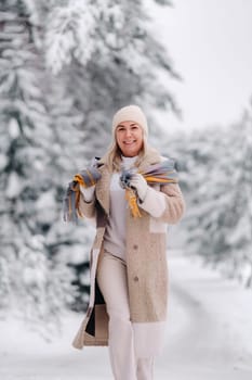 A cheerful woman in warm clothes walks in the winter.