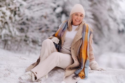 A cheerful woman in warm clothes walks in the winter.