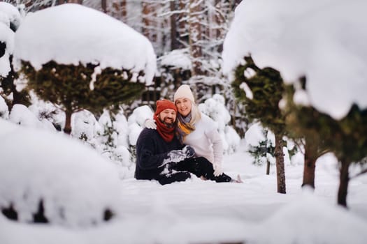 A cheerful couple, a man and a woman on the street in the snowy season.