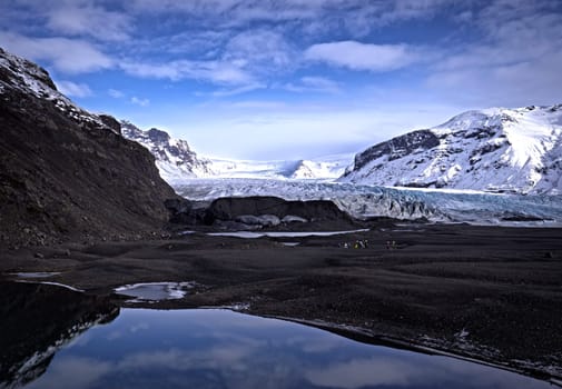 A mountain range with a body of water in the foreground