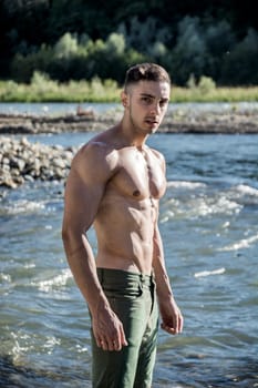 A shirtless man standing in the water