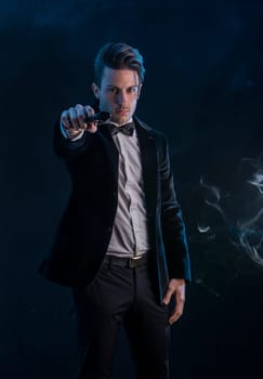 A man in a tuxedo pointing a gun at the camera