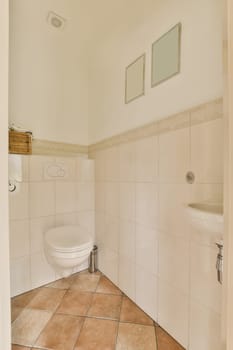 a small bathroom with tile flooring and white tiles on the walls there is a toilet in the corner next to the sink